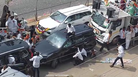 Party activists take cover behind vehicles during clashes