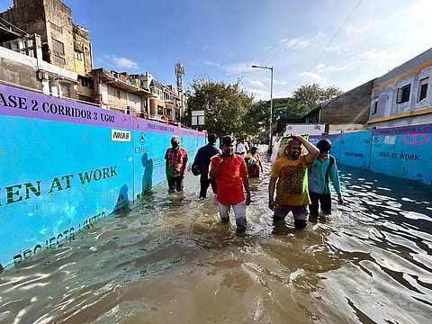 People wade through a waterlogged road in Chennai