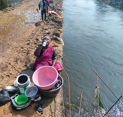 A Semmencherry resident washing dishes by a lake