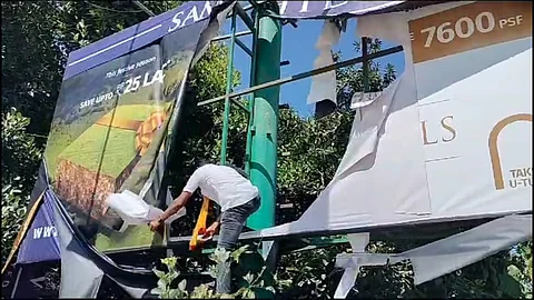 KRV protestors tearing a billboard