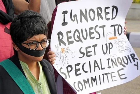 A woman at a protest with black cloth around her mouth