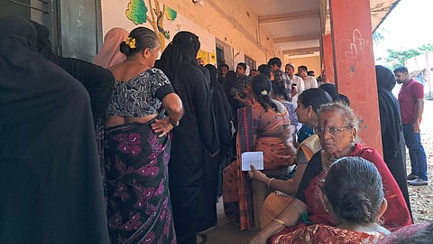 Voters wait in queue at the Badiyadka Government School in Kasaragod
