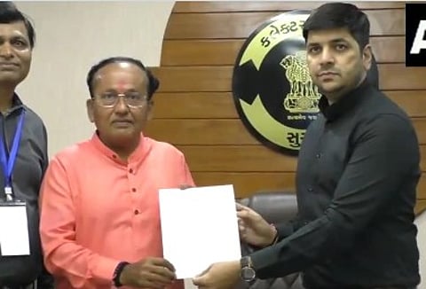 Surat district Returning Officer Sourabh Pardhi handing over election certificate to BJP's Mukesh Dalal