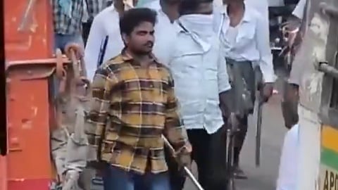 A group of men walking with sticks and other weapons in Macherla, Andhra Pradesh