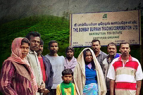 A group of tea estate workers, against the backdrop of Manjolai hills and a name board saying 'The Bombay Burmah Trading Corporation Ltd'