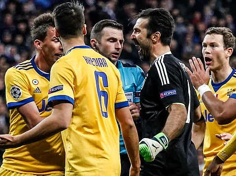 Referee Michael Oliver (in blue) is abused by Juventus goalkeeper Gianluigi Buffon during a 2018 Champions League tie. Afterwards, Oliver and his wife were sent abusive emails and texts, including death threats.