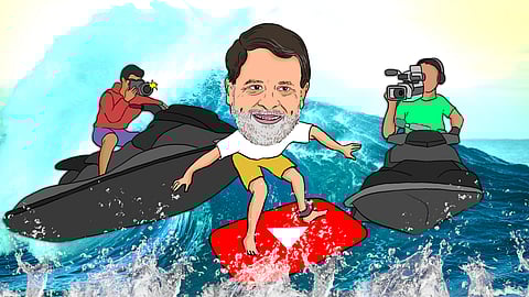 Illustration of Congress leader Rahul Gandhi riding a wave on a large YouTube play button surfboard, symbolizing his online presence and popularity. He has a cheerful expression, wearing a white t-shirt and yellow shorts. On either side, two men on jet skis capture him in action, one with a camera and the other with a video recorder. The background features splashing ocean waves, adding to the energetic and playful tone of the scene. Illustrated by Shambhavi Thakur.