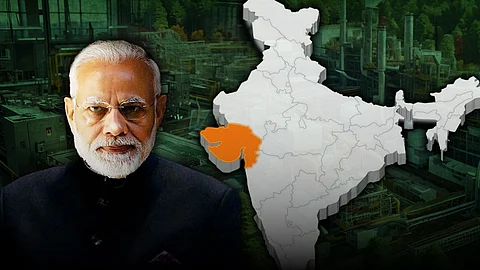 Image of Indian Prime Minister Narendra Modi on the left side, with a map of India on the right highlighting the state of Gujarat in orange. The background shows an industrial setting with factories and machinery, suggesting themes of development, industry, or regional focus.
