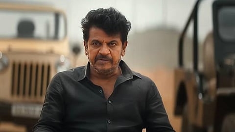 Screenshot of Shiva Rajkumar dressed in black, facing the screen, from the trailer of the film.