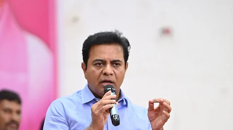 BRS leader KTR in a blue shirt and dark blue pants speaking into a mic