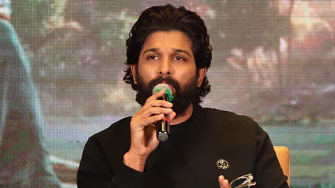 Actor Allu Arjun in a black full sleeved t shirt speaking into a mic