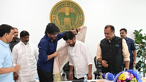 Actor Nagarjuna wrapping a shawl around Telangana Chief Minister Revanth Reddy