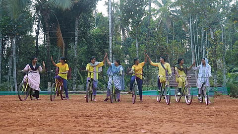 Eight women on cycles at one end of a playground