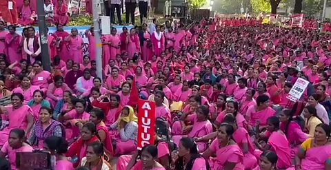 Hundreds of Asha workers sit on the road at the protest site outside the Kerala Secretariat. They are all dressed in bright pink sarees or kurtas