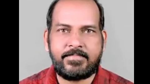 Portrait of Subramanian in a red checkered shirt, looking directly at the camera