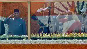 President Droupadi Murmu salutes while unfurling the national flag at Kartavya Path