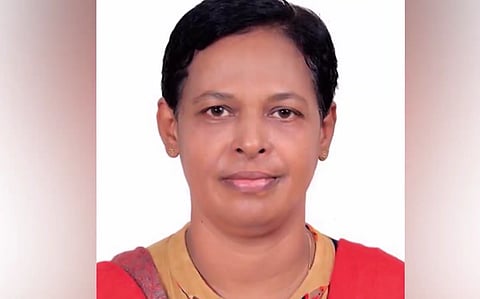The woman dressed in a yellow shirt and red scarf, a passport size photo.