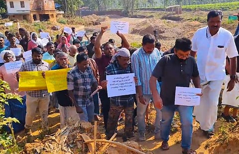 A group of Survivors protest in Mundakkai area, holding placards with messages in Malayalam