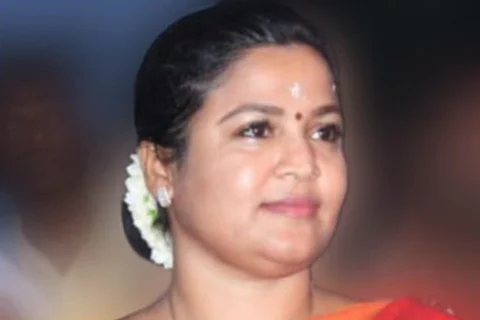 Ranjana Natchiyaar in a a red and orange saree.