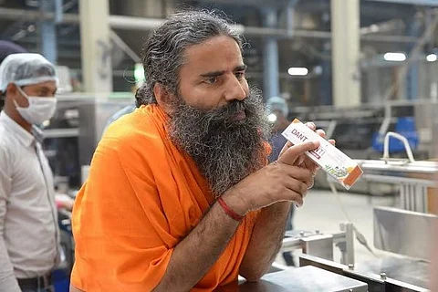 Image of Baba Ramdev holding "Dant Kanti" toothpaste.