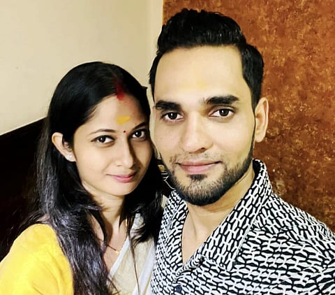 Asha Verma and Mohammed Ghalib smiling for a selfie indoors, with Asha in traditional attire and Mohammed in a patterned shirt.