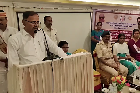 Mayiladuthurai collector AP Mahabharathi, in a white shirt, speaking from behind a podium at a POCSO Act awareness programme.
