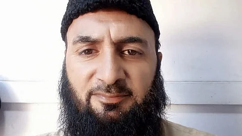 A middle-aged man with a black beard and a traditional tall black cap (possibly a Karakul hat) is taking a selfie. He is wearing a beige or light brown kurta, standing against a plain white background. The timestamp on the image shows the date "2022/09/11 17:22."