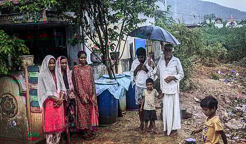 A family in Palnadu district's Bollapalli mandal stands next to cans which have been placed to collect rainwater.