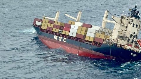 The image shows the container vessel, tilted to the right, in the sea.