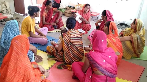 A digital didi in Uttar Pradesh explaining how to use a reusable cloth pad to the women of her community