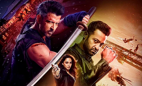 Promotional poster for the action film War 2, featuring Hrithik Roshan holding a blood-stained sword in a combat stance on the left, N. T. Rama Rao Jr. (Jr NTR) with clenched fists on the right, and Kiara Advani in the center aiming a gun at the viewer, with an intense battle scene and explosions in the background.