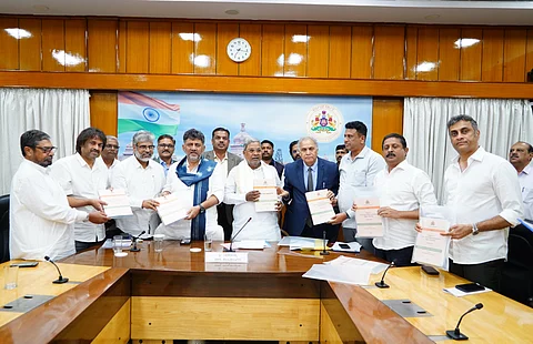 Scholar Sukhdeo Thorat (in blue suit) submits the State Education Policy report to Chief Minister Siddaramaiah.