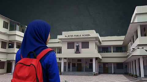 A girl wearing a blue hijab and red backpack stands facing St. Rita’s Public School building, which has a statue of a nun above the entrance under a dark cloudy sky.