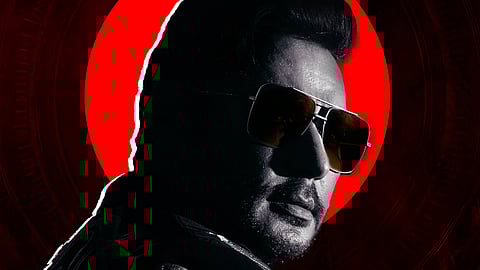 Promotional poster for Darshan’s Kannada film Devil. The image shows a stylised black-and-white profile of Darshan wearing sunglasses, set against a bright red circular backdrop. At the top, bold gold text reads “In Cinemas 11.12.25”. The bottom section carries the film’s title in Kannada script and production credits. The overall colour scheme is dark red and black.