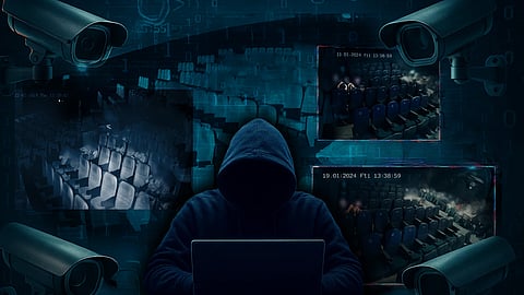 An image of a hacker, who is wearing a hoodie in the middle. Around him are the blurred screenshots of CCTV footage from movie theatres