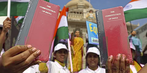 Students hold a copy of the consitution during a rally marking the Constitution Day celebrations at Vidhana Soudha in Bengaluru on November 26, 2025.