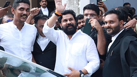 Actor Dileep in a white shirt waving to supporters outside the Ernakulam Principal Sessions Court after being acquitted in the actor assault case