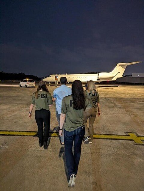 FBI agents escort Zobaidul Amin to an airplane in Kuala Lumpur, Malaysia, on Wednesday, March 4, 2026, for transport to Anchorage, Alaska, where he faces charges of child pornography and exploitation.