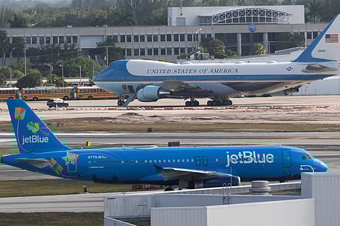 A JetBlue passenger jet, front, taxis at Palm Beach International Airport, Sunday, March 30, 2025, in West Palm Beach, Fla.