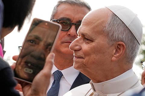 The head of Vatican Security, Gianluca Gauzzi Broccoletti, center, follows Pope Leo XIV as he visits the parish complex of Santa Maria della Presentazione on the outskirts of Rome, Sunday, March 8, 2026.