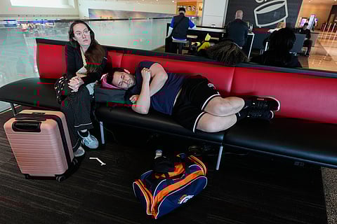 Jamie Sims left, and Carlos Serna, right, try to get some rest as they wait for their cancelled flight to El Paso, texas to be rescheduled at Love Field Airport in Dallas, Monday, March 16, 2026.