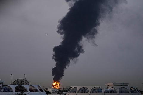 Fire and plumes of smoke rise after a drone struck a fuel tank forcing the temporary suspension of flights. near Dubai International Airport, in United Arab Emirates, early Monday, March 16, 2026.