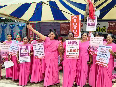 Rekha, an ASHA worker, with her fist raised during a protest.