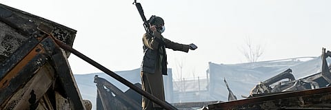 A Taliban fighter inspects the site of a Pakistani strike in Kabul on March 17, 2026.