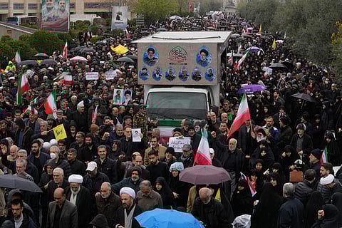 Iranians follow a truck carrying the coffins of Iran's intelligence minister Esmail Khatib and, according to Iranian officials, his wife and daughter, during a funeral procession in Tehran, Iran, Friday, March 20, 2026.
