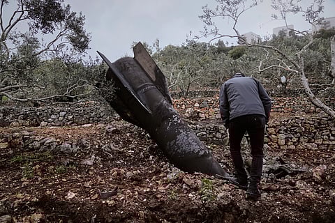 A man inspect the wreckage of an Iranian missile that landed near the West Bank village of Marda, Tuesday, March 31, 2026.