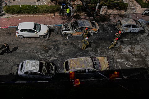 Israeli security forces and rescue teams inspect a site struck by an Iranian missile in Petah Tikva, Israel, Tuesday, March 31, 2026. (AP Photo/Ohad Zwigenberg)