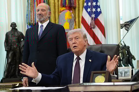 President Donald Trump answers questions from reporters after signing an executive order in the Oval Office of the White House Tuesday, March 31, 2026, in Washington, as Commerce Secretary Howard Lutnick listens.