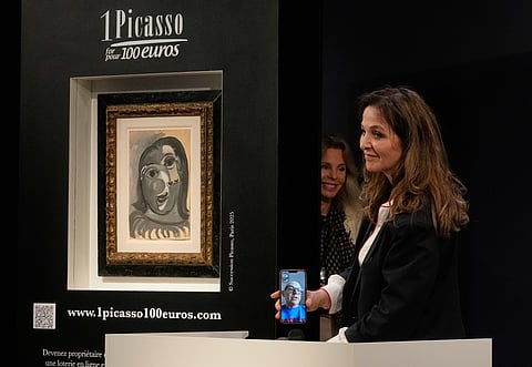Peri Cochin, right, founder of "1 Picasso for 100 euros," speaks on the phone with the winner, Ari Hodara of Paris, next to the painting 'Head of a Woman' by Pablo Picasso, painted in 1941, after the raffle draw at Christie's in Paris, Tuesday, April 14, 2026, in support of Alzheimer's research.
