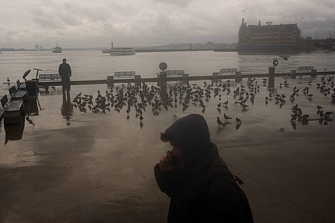 A man stands next to the Bosphorus at Kadikoy ferry terminal on a rainy day in Istanbul, Turkey, Wednesday, April 22, 2026.